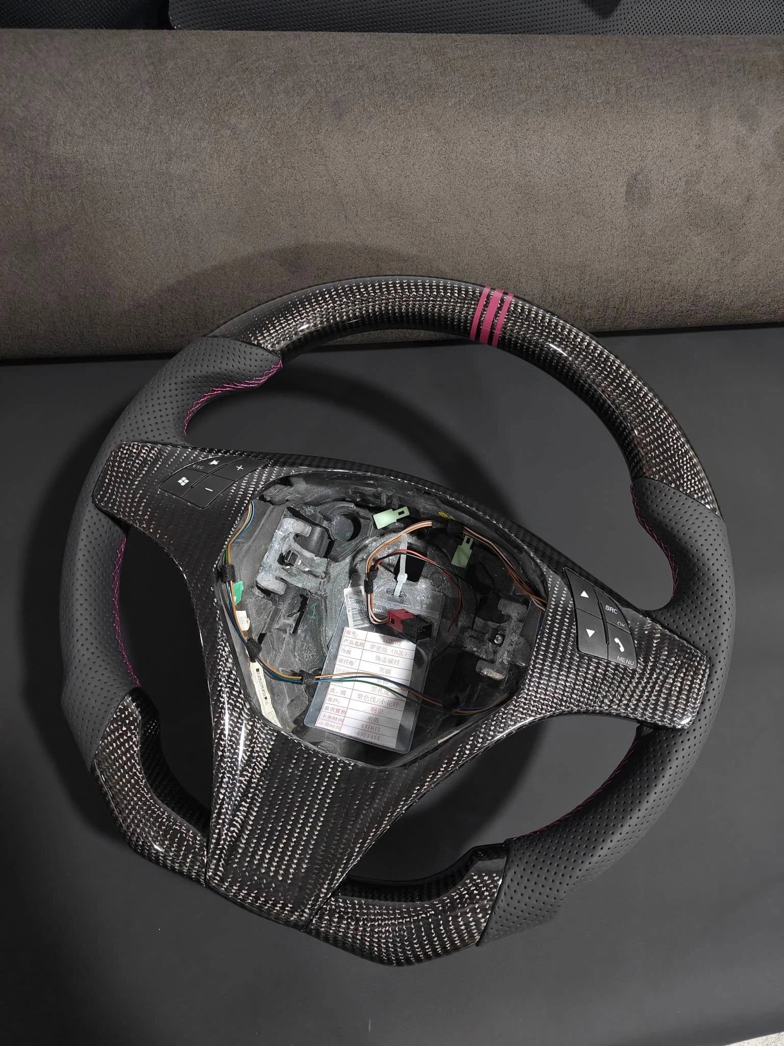 Romeo and Juliet carbon fiber steering wheel paired with purple return-to-center emblem, wrapped in perforated black leather