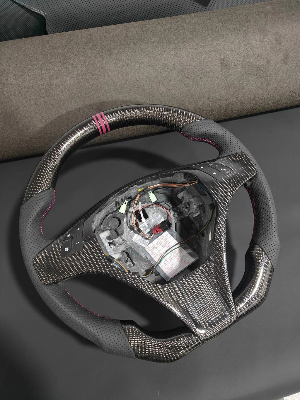 Romeo and Juliet carbon fiber steering wheel paired with purple return-to-center emblem, wrapped in perforated black leather