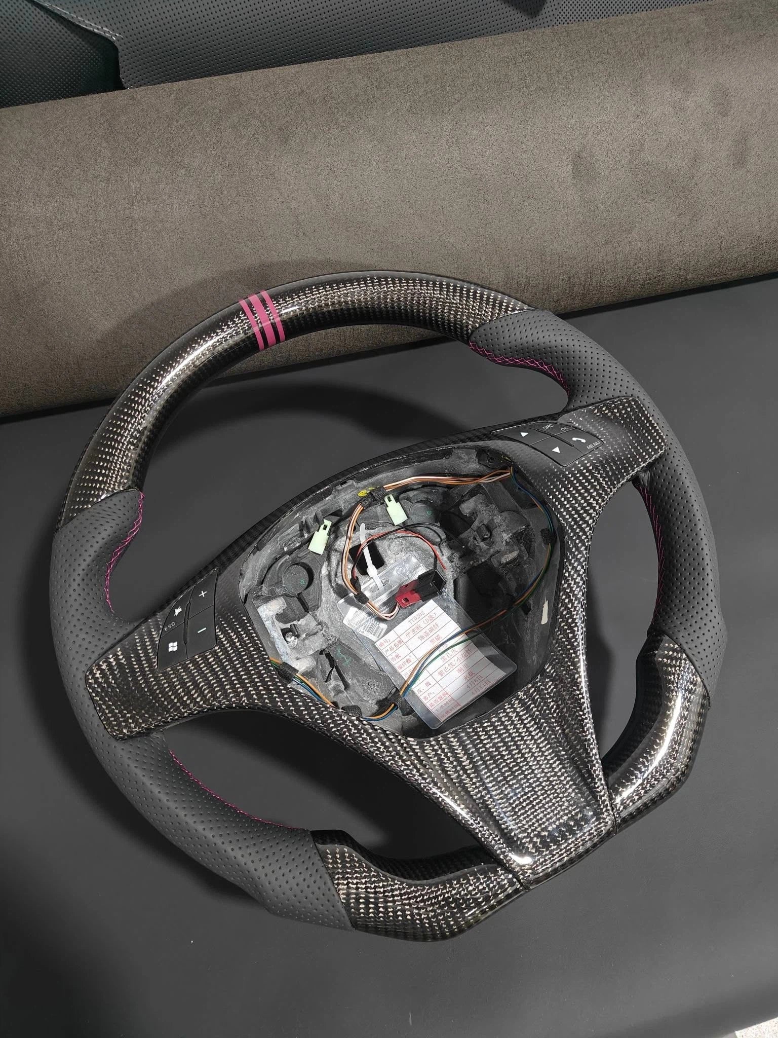 Romeo and Juliet carbon fiber steering wheel paired with purple return-to-center emblem, wrapped in perforated black leather