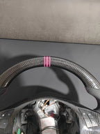 Romeo and Juliet carbon fiber steering wheel paired with purple return-to-center emblem, wrapped in perforated black leather